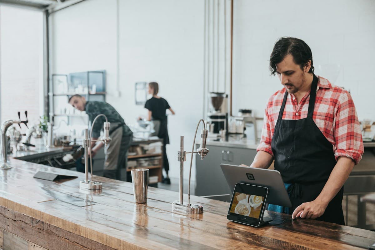 A hospitality worker using a device behind the counter