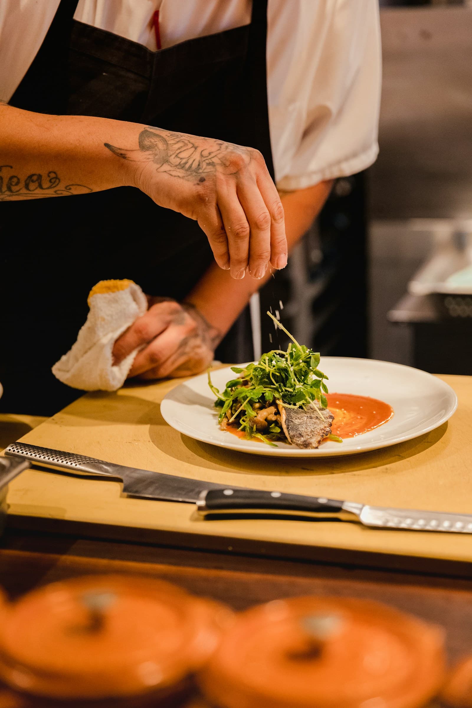 A chef plating a dish in a restaurant kitchen